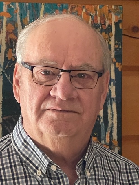 Headshot for Board Member, Gary Guenther in a plaid shirt and wearing glasses