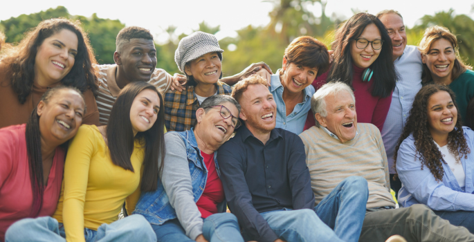Image of a big group of diverse people smiling, laughing and connecting while posing for a picture