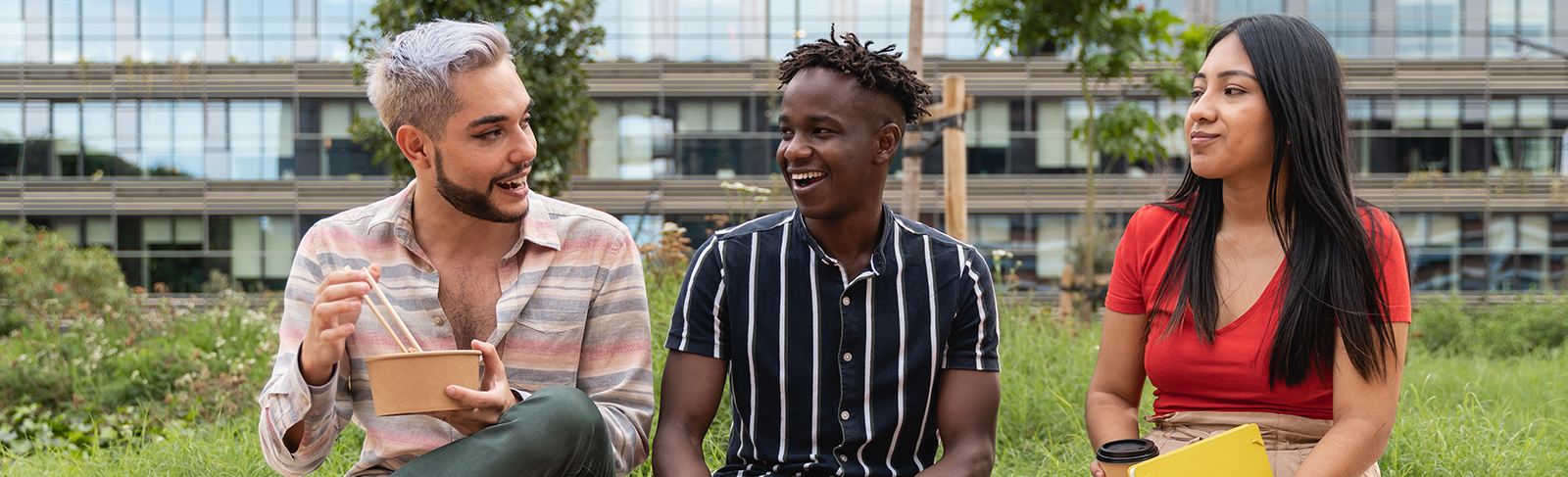 Three people sitting together outside on a sunny day