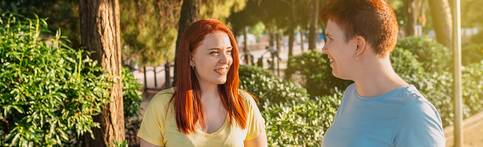 Two people with red hair having a conversation while standing outside