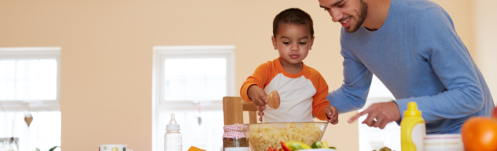 Father and son making pasta salad