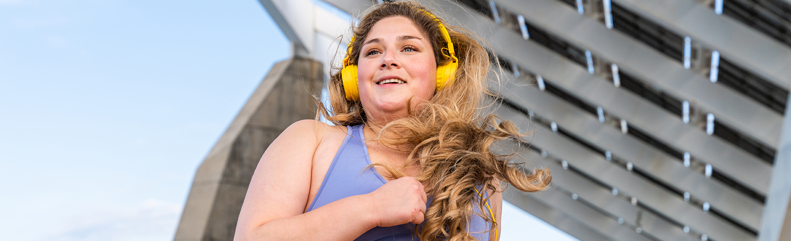 Lady running with yellow headphones
