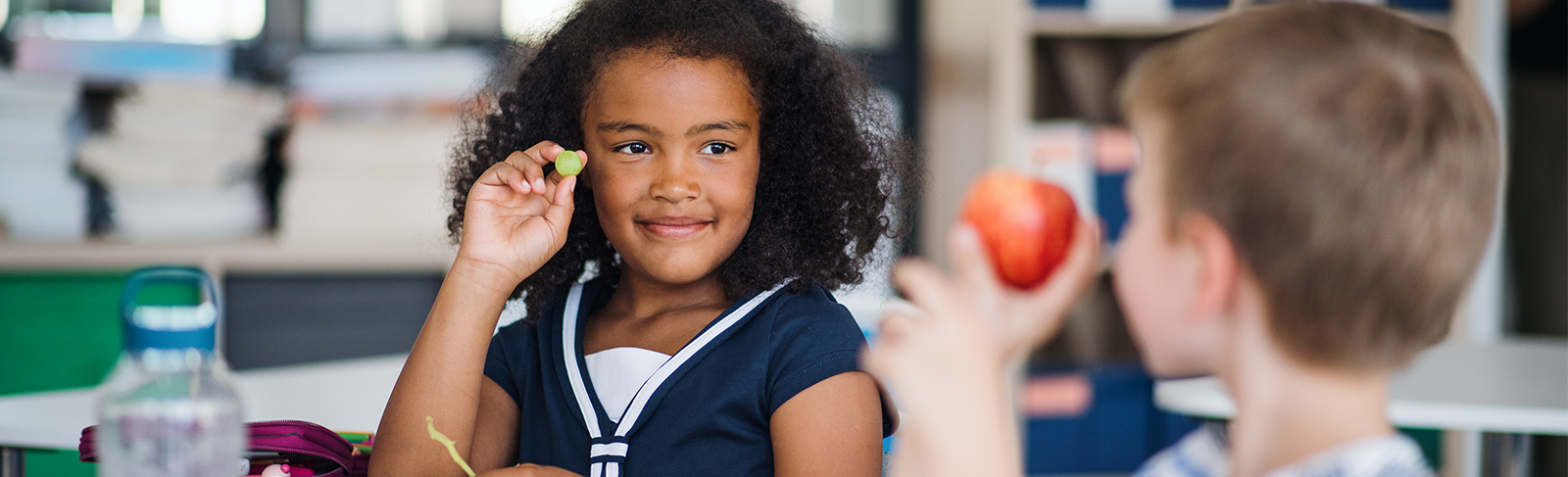 Child eating with a child in front