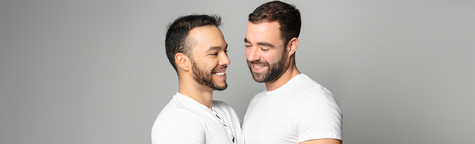Two men in white shirts holding each other