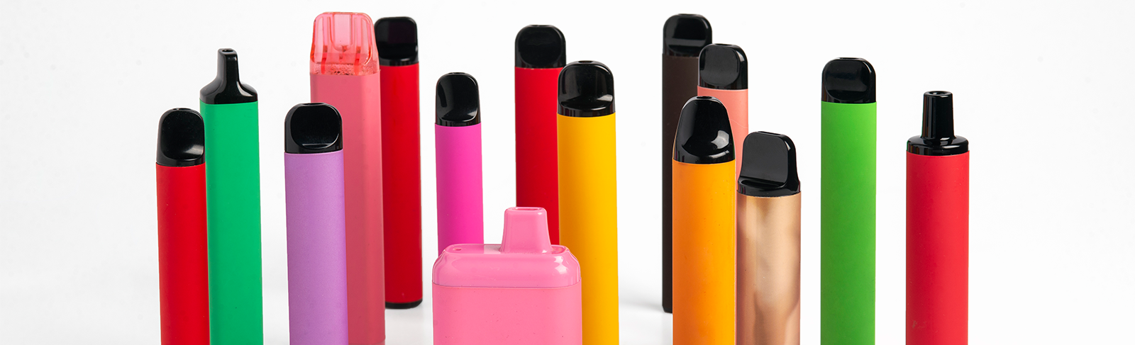 A number of different coloured vape products on a white background.