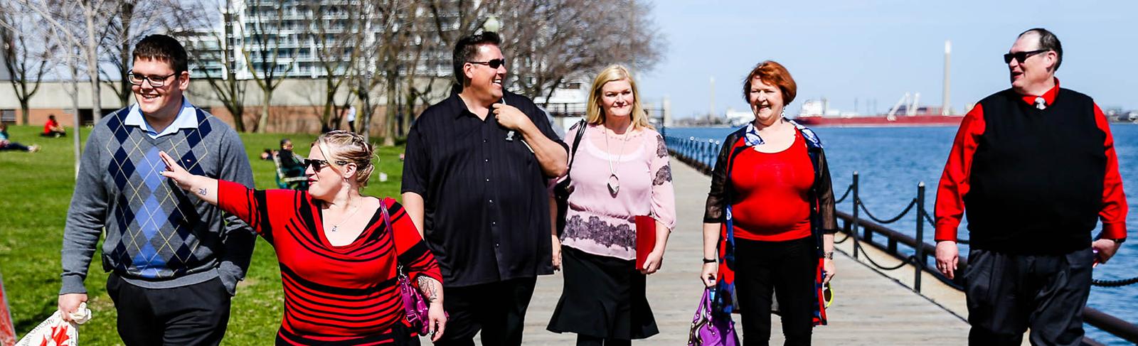 Group of people walking on a board walk.