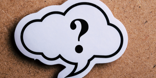 Image of a question mark on a piece of paper. The paper is shaped like a thought bubble and overlaps a bulletin board background.