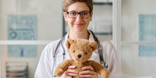 Image of a paediatric health professional holding a teddy bear