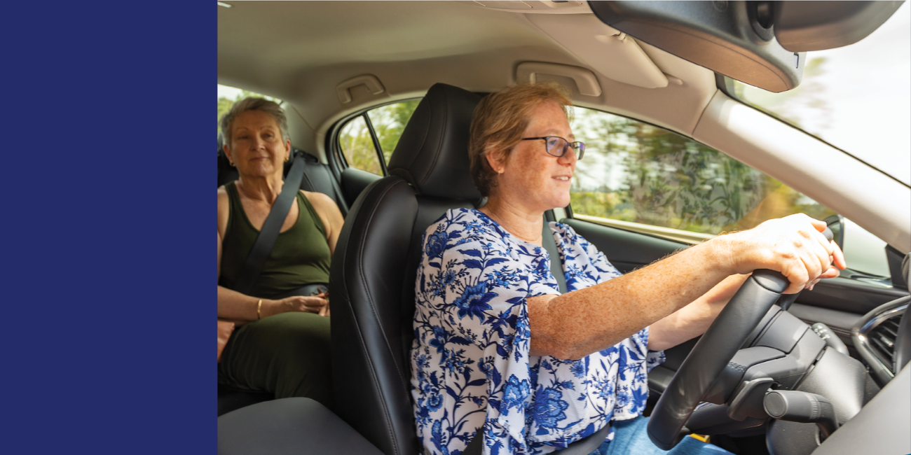 Image of a person driving with a passenger in the backseat