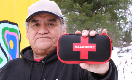 Man holding up a naloxone kit