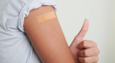 Image of an arm with a band aid on it. 