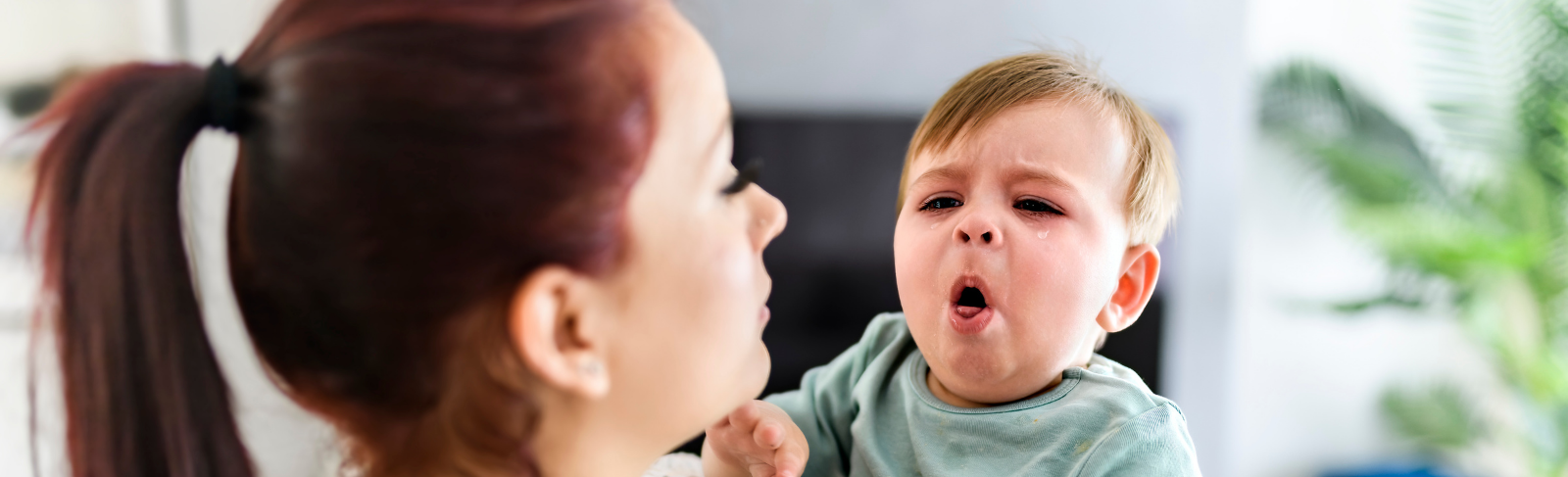 Le nourrisson tousse alors qu'il est dans les bras d'une femme