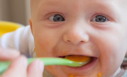 Baby being fed by spoon
