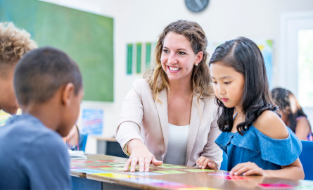 Image of a teacher connecting with a small group of students in a classroom setting