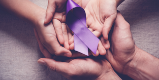 Image of hands overlapping, plam facing up, holding a purple cause ribbon