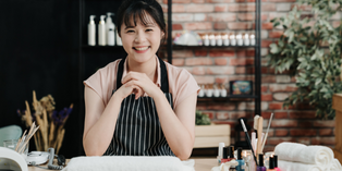 Happy nail salon owner at desk