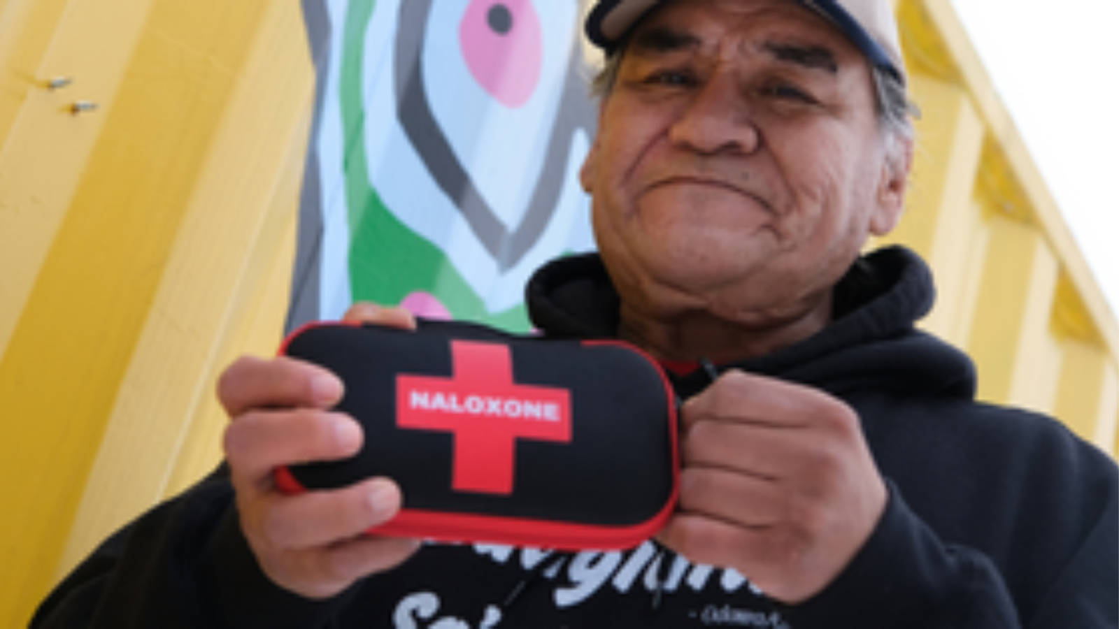 Image of a person holding a naloxone kit.