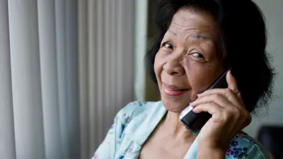 Older adult holding phone to ear and smiling