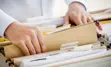 Hand pulling a folder out of a drawer of file folders