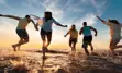 Image of young people running through shallow lake water toward sunset